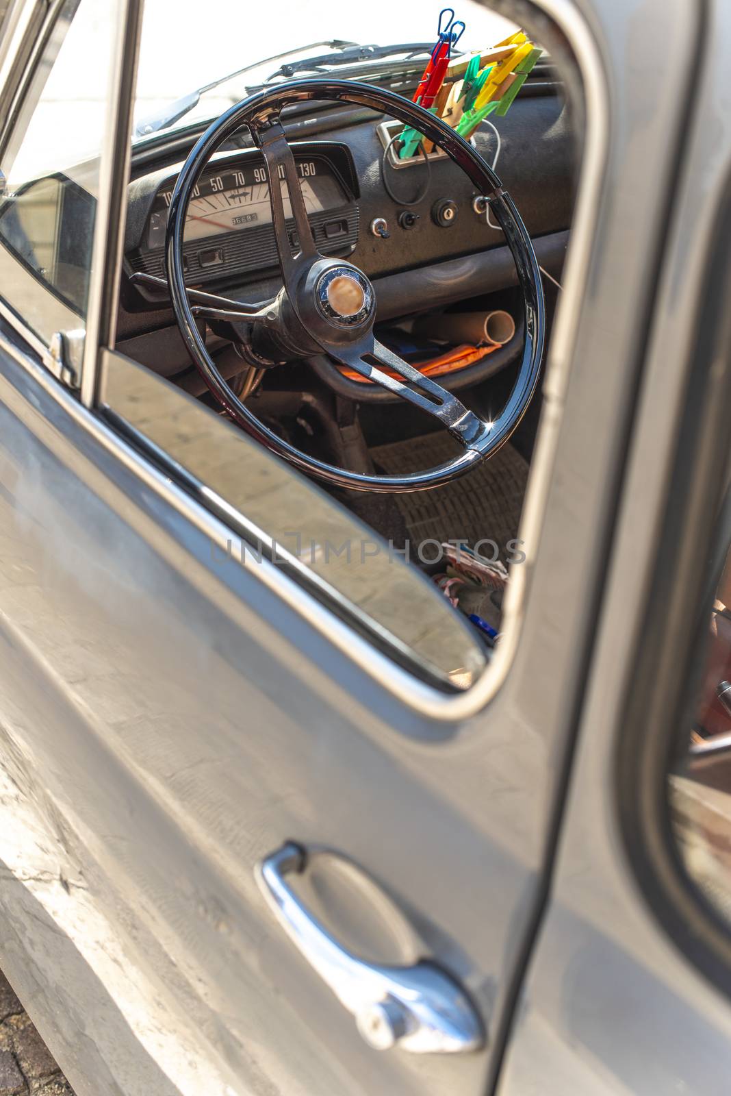 Steering wheel on vintage car. View from the door window. Opened window on old vintage car.