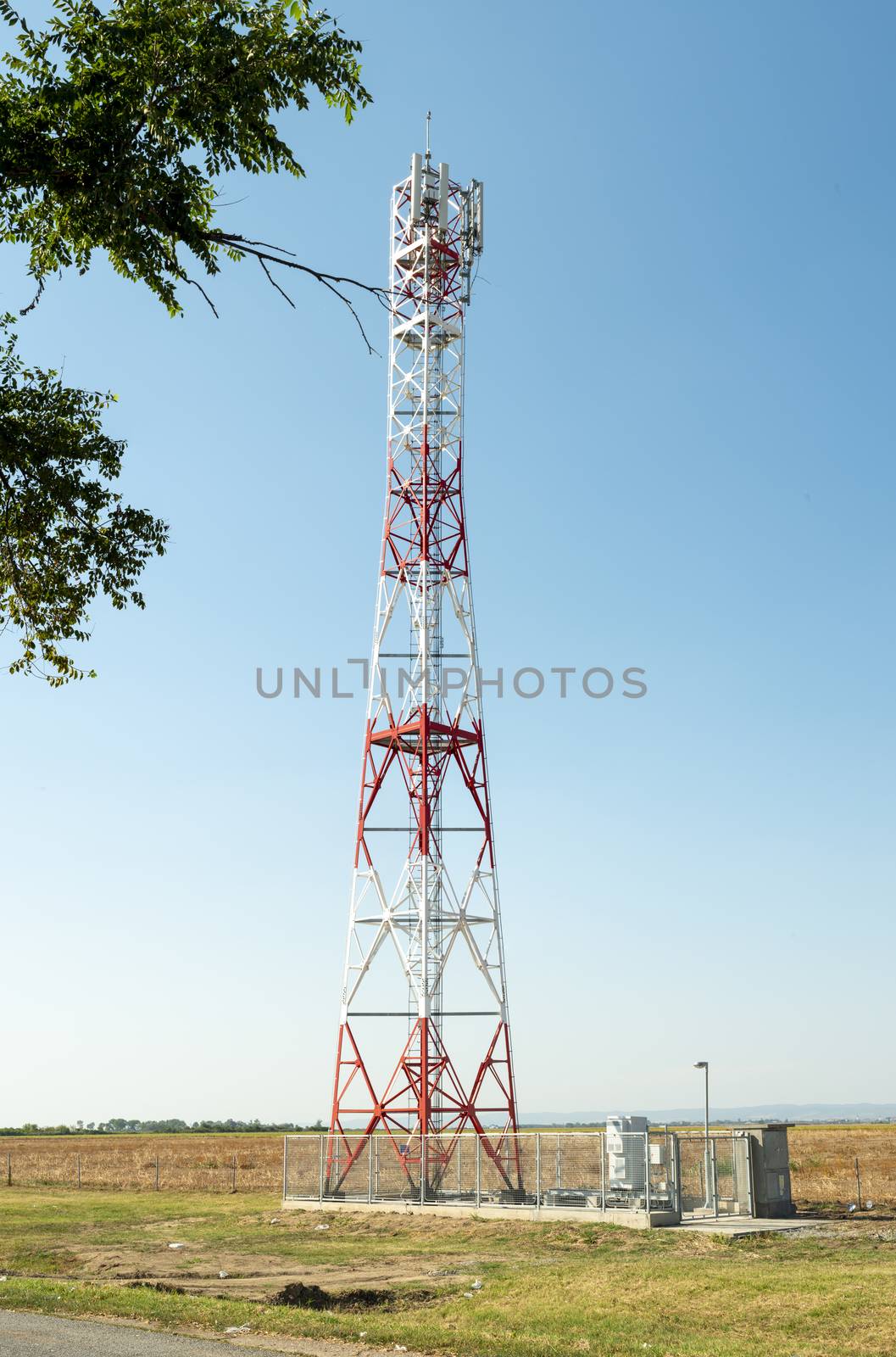 5G antenna for high speed internet distribution. 5G repeaters outside the city. Bright colours red and white.