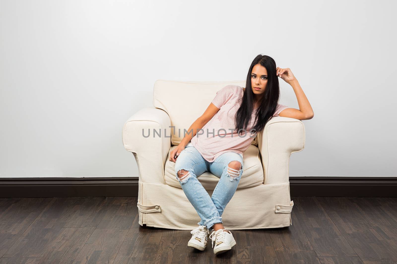 mid-twenties woman, sitting on a couch with casual clothes