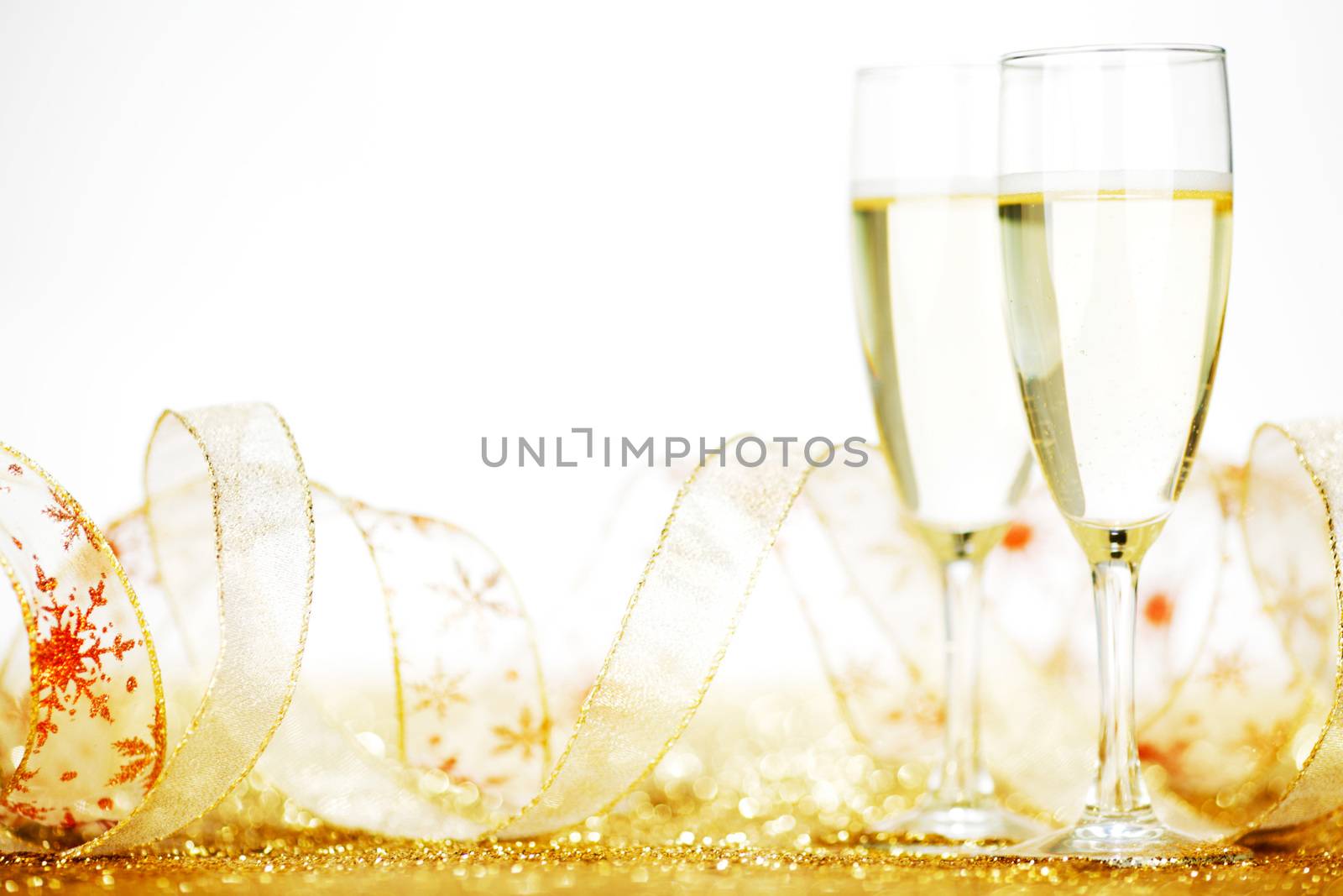 Two glasses of champagne with bow on golden background