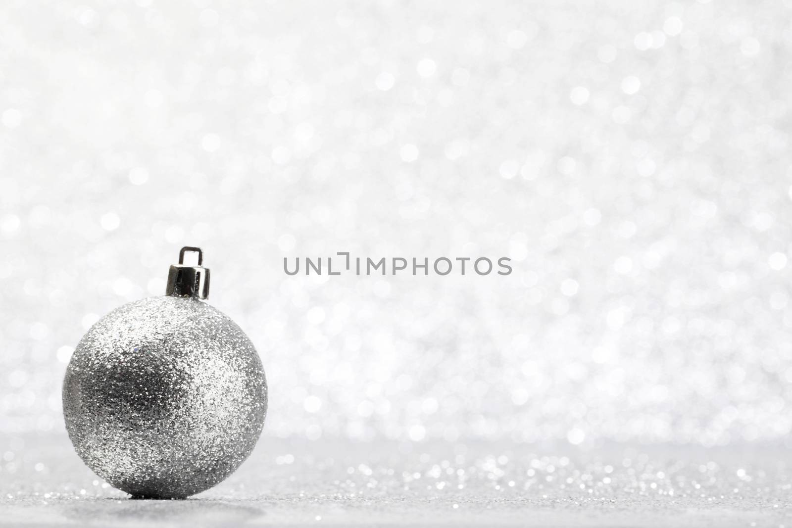 Christmas decorative ball on light silver bokeh background