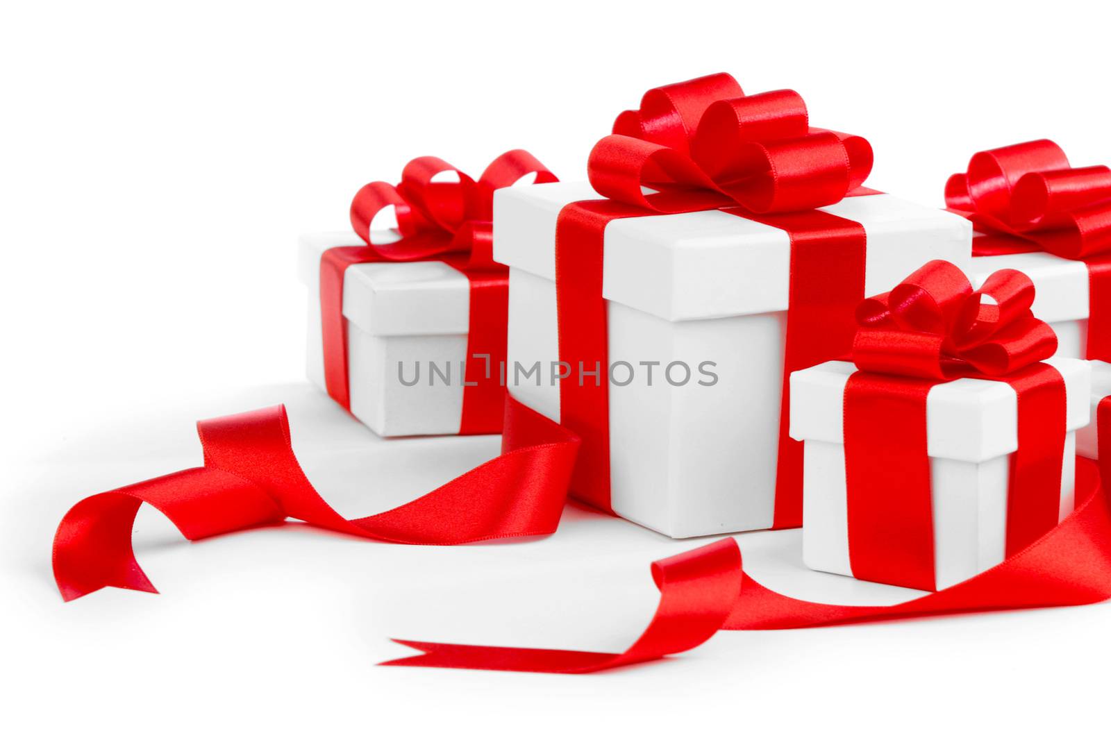 White gift boxes with red ribbon bows isolated on white background close-up