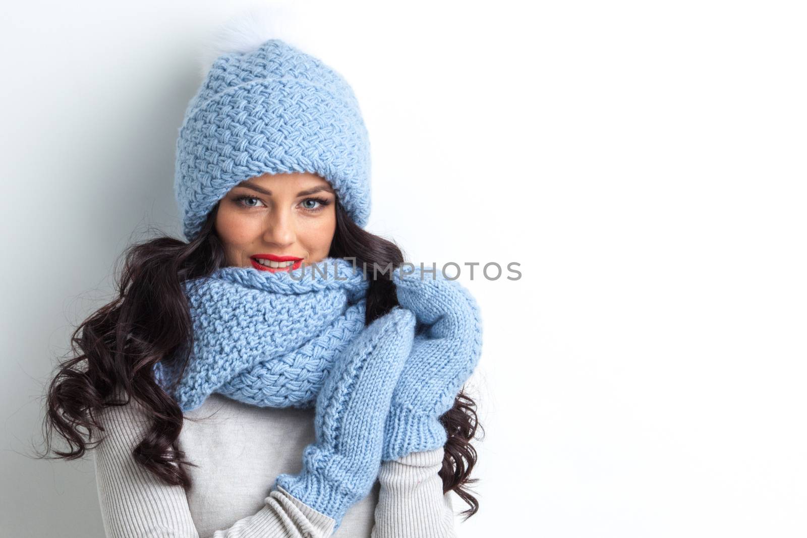 Beautiful woman in warm hat, mittens and scarf on white background