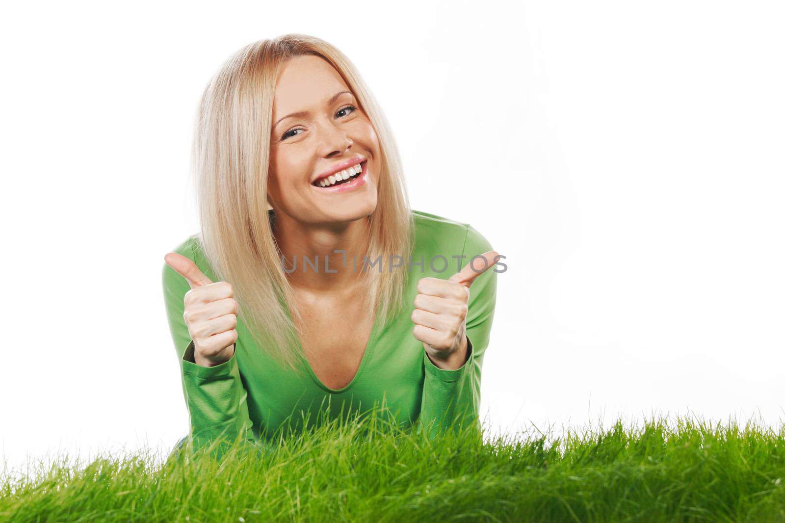 Young beautiful woman lying on grass with thumbs up, isolated on white background