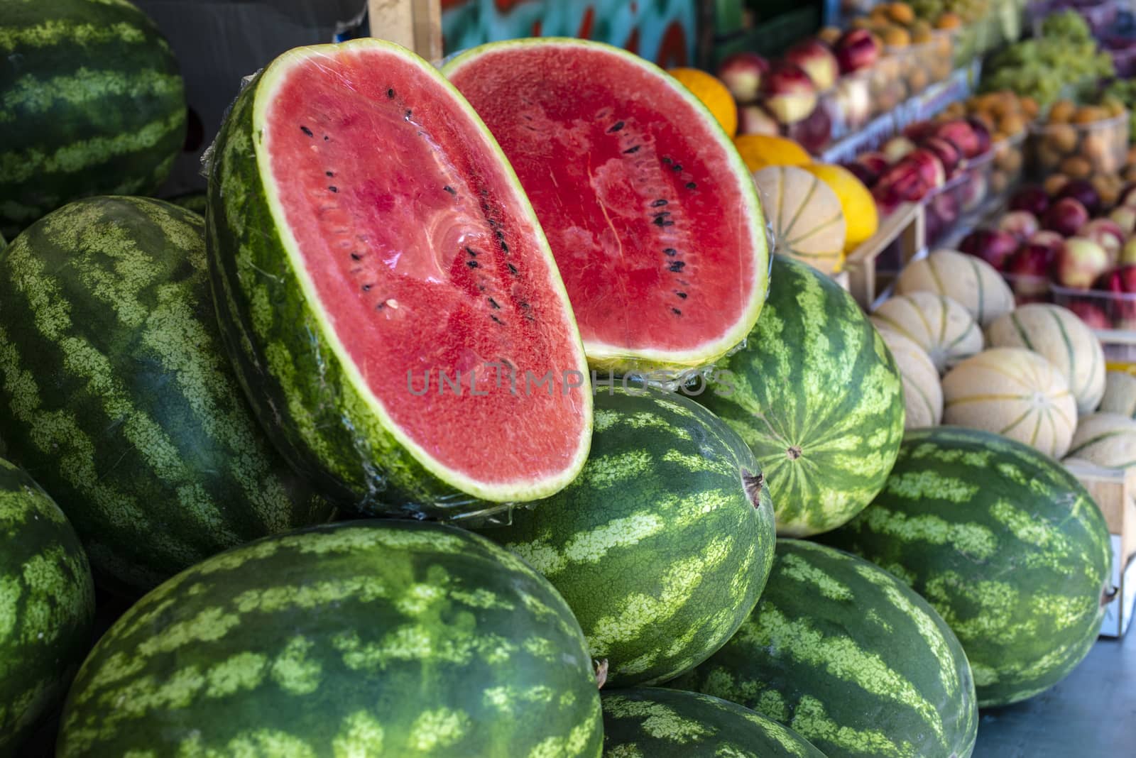 Watermelons on shelf. Cutted watermelon on street market by deyan_georgiev