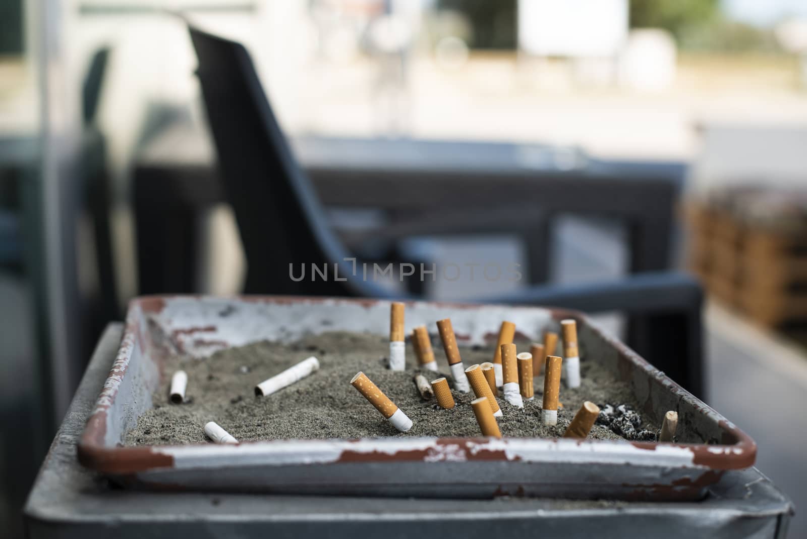 Ashtray with sand and buried cigarettes. by deyan_georgiev