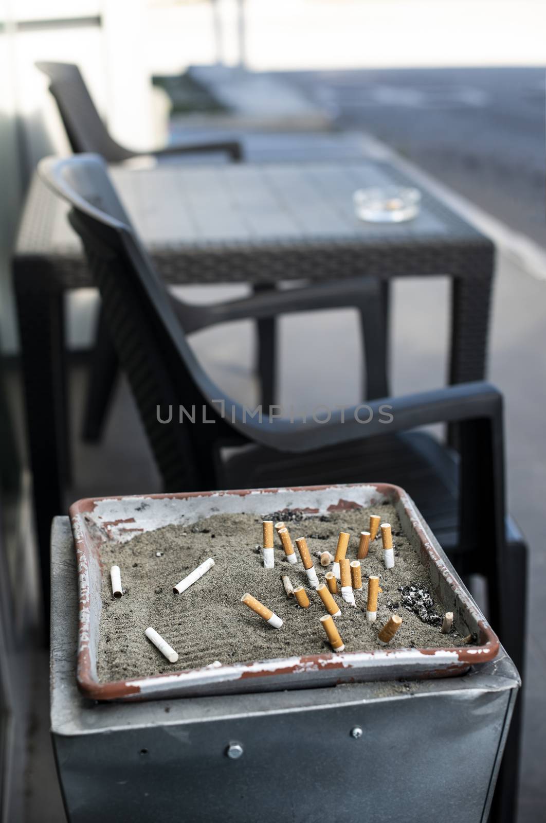 Ashtray with sand and buried cigarettes. by deyan_georgiev