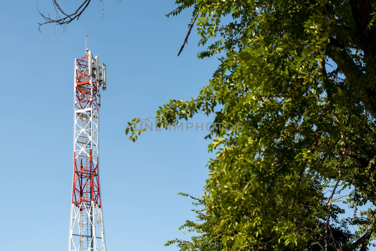 5G antenna for high speed internet distribution. 5G repeaters outside the city. Bright colours red and white.