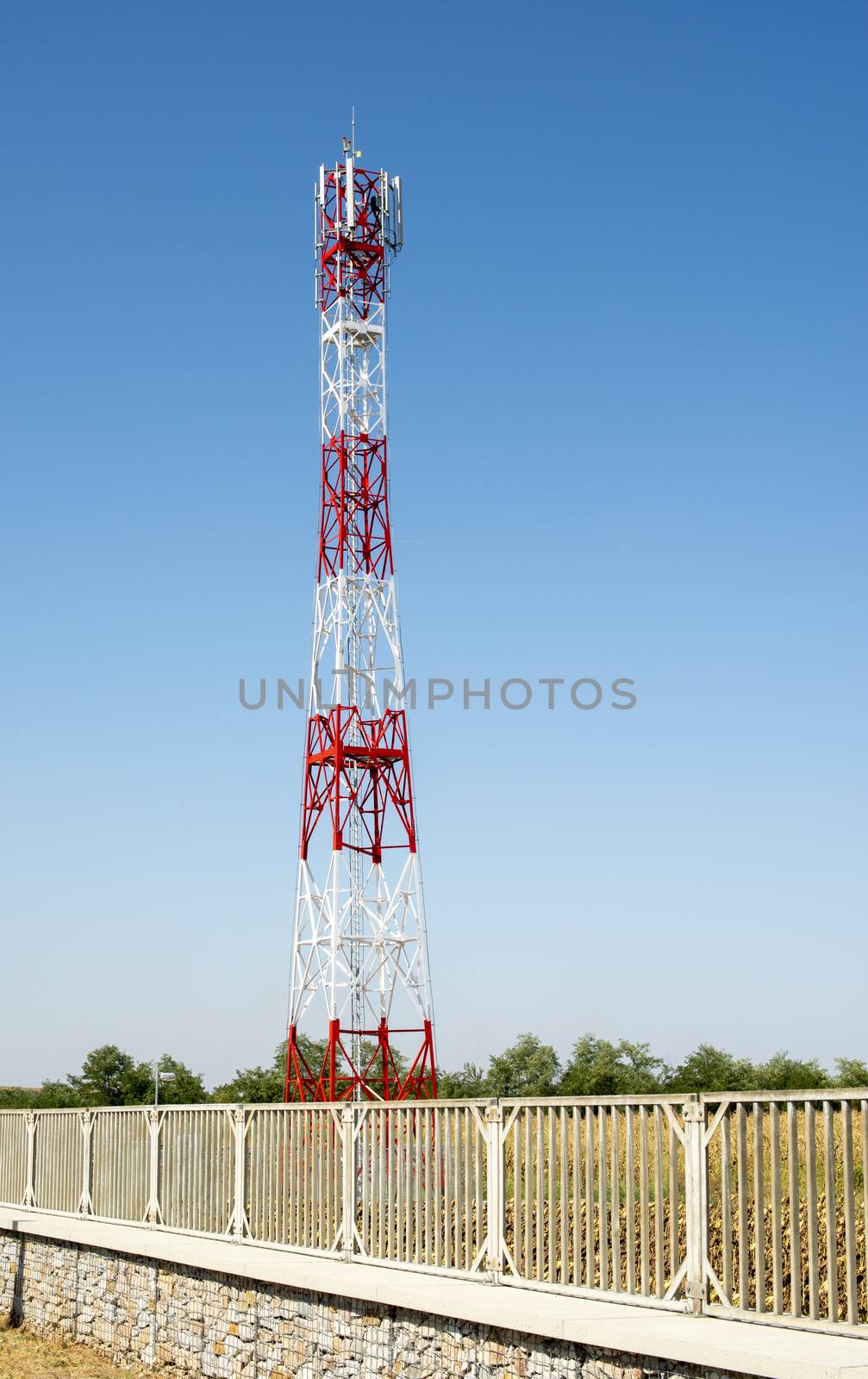 5G antenna for high speed internet distribution. 5G repeaters outside the city. Bright colours red and white.