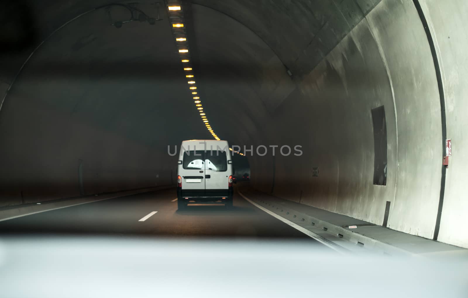 Bus traveling in highway tunnel. Tunnel lights.