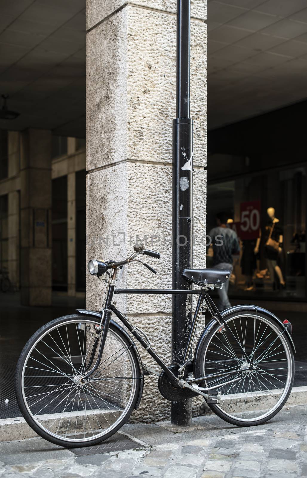 Black bike in front of fashion shop on italian street. by deyan_georgiev