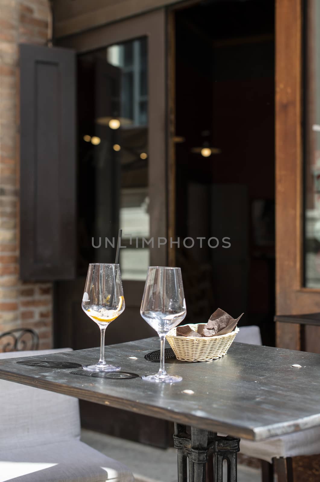 Restaurant on italian street. Two empty glasses of wine on table.