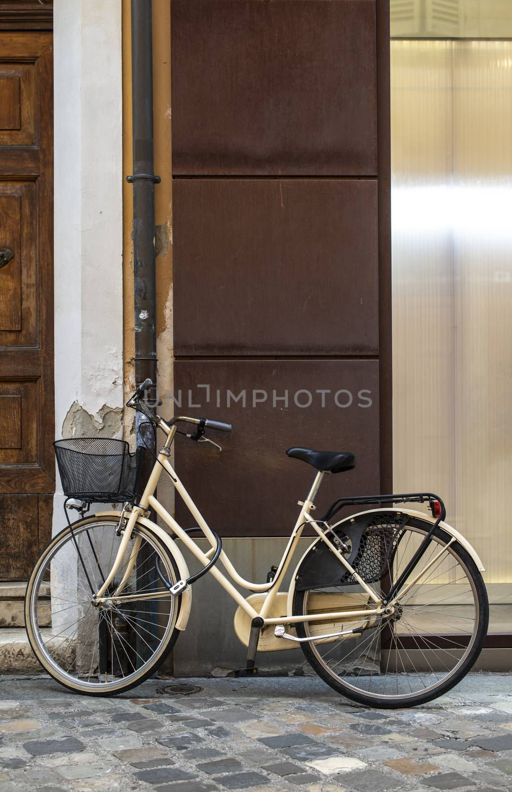Beige bike with basket on italian street. Typical italian architecture on background. Sunny day. Typical italian style.