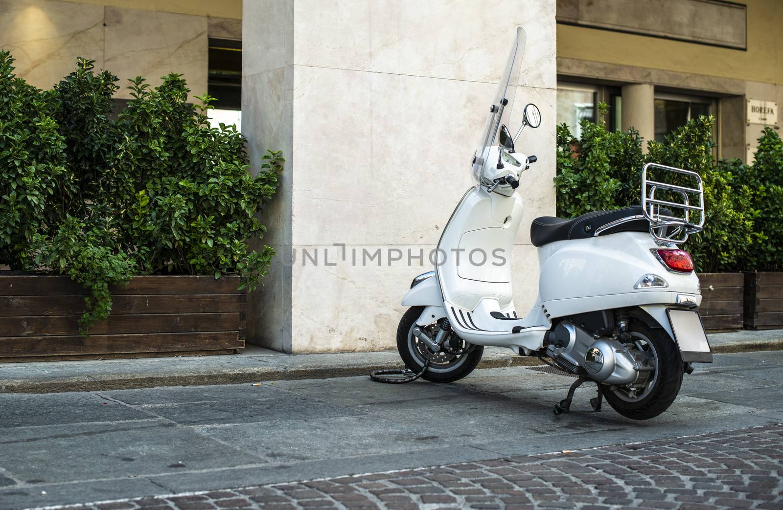 White italian scooter on italian street. Typical italian architecture on background. Typical italian motorbike style.