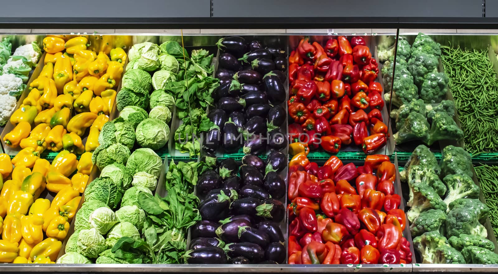 Vegetables on shelf in supermarket.  Peppers, broccoli and beans.