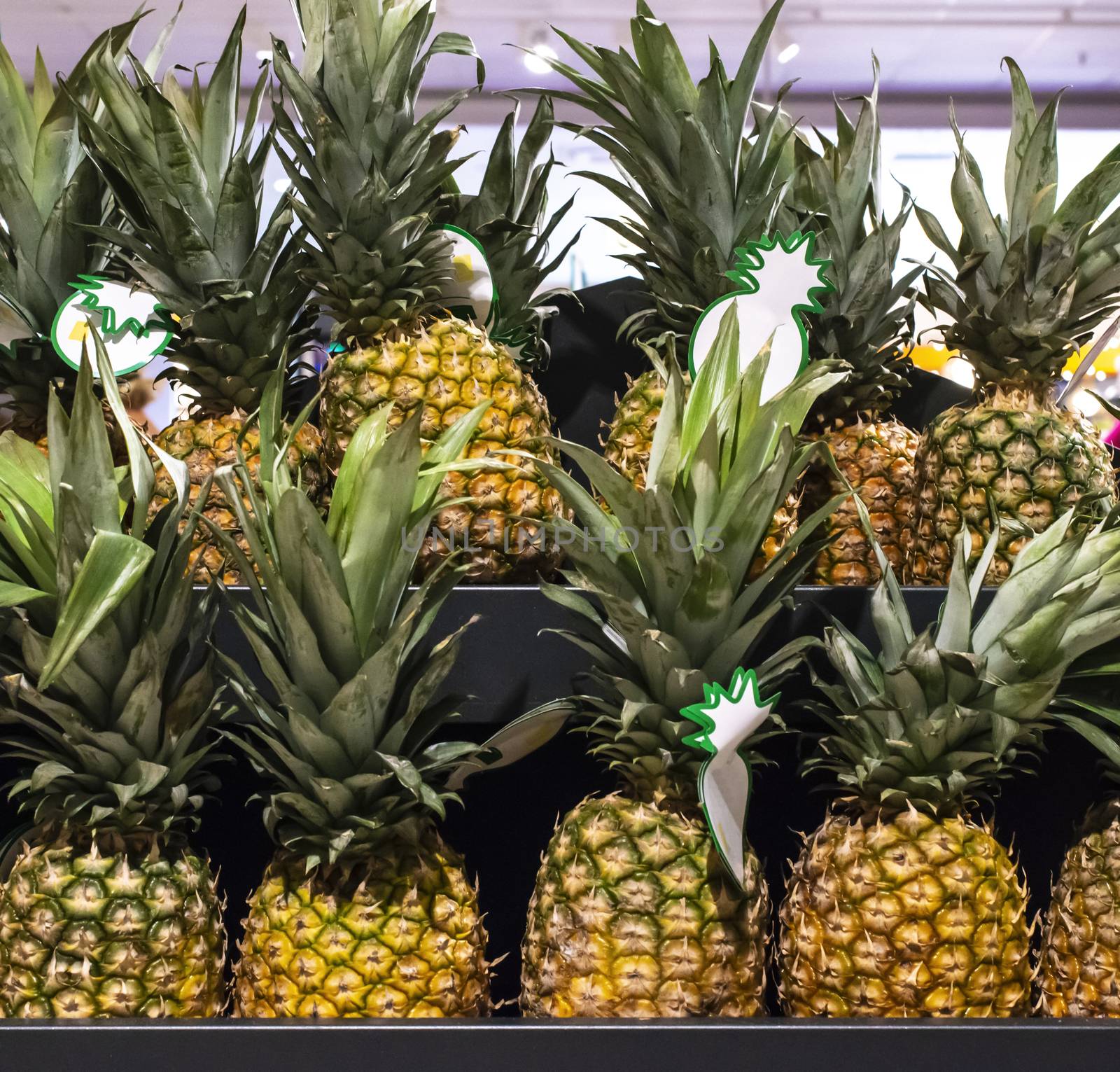 Ananas on shelf in supermarket. by deyan_georgiev