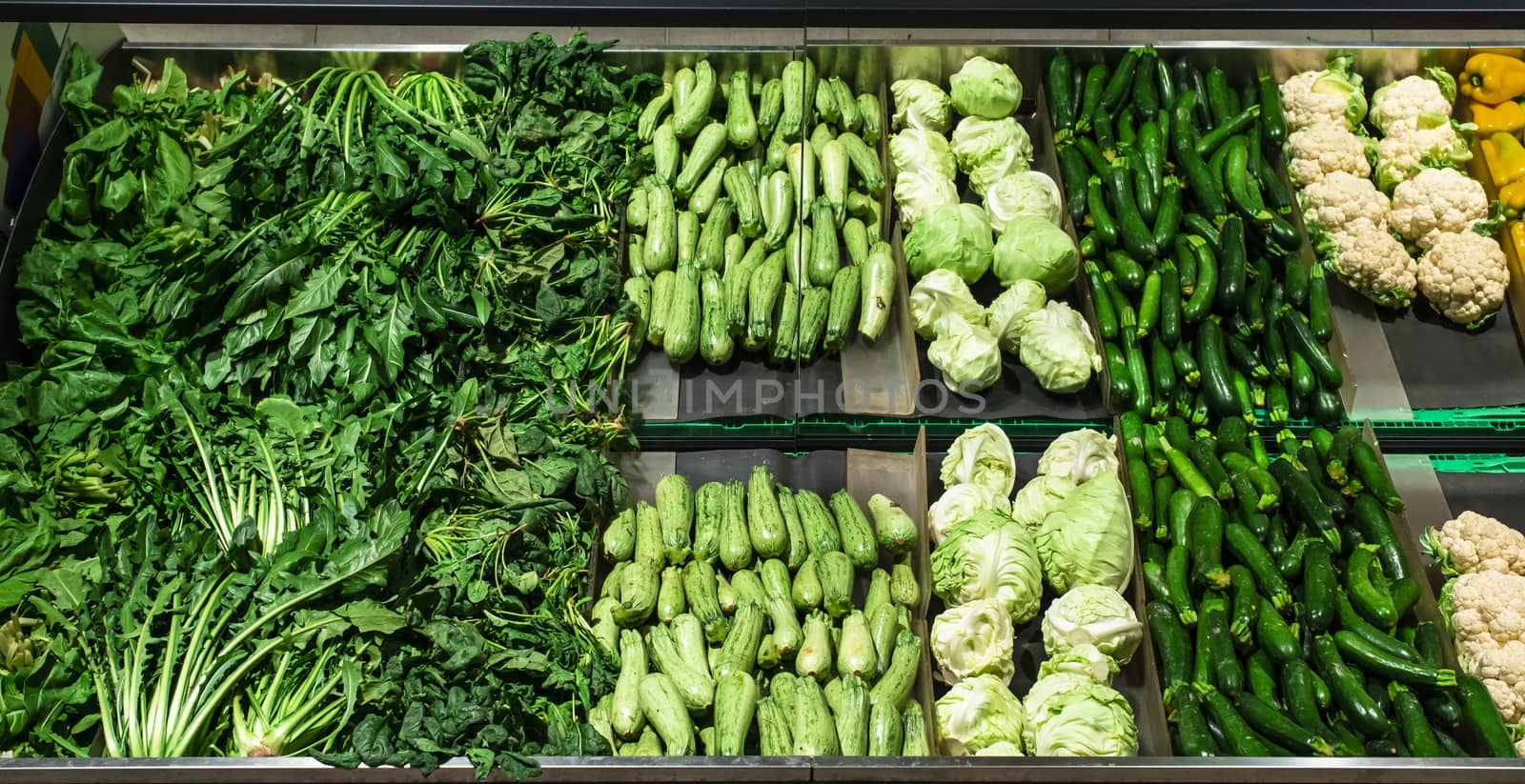 Vegetables on shelf in supermarket. Cabbage, zucchini, pepper and cauliflower.
