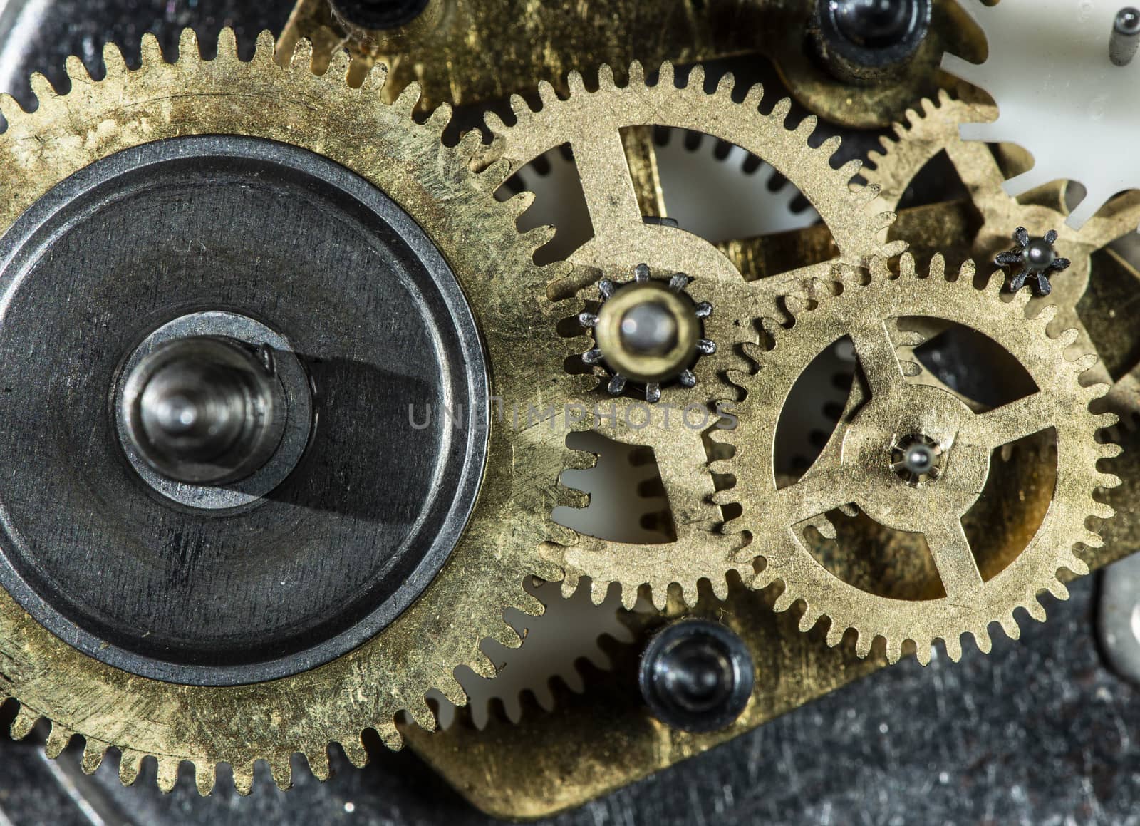 Close up metal gears mechanism. Golden colours. Hard light. Clock interior mechanism parts.