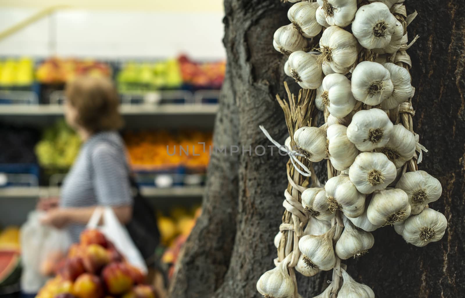 Bundle garlic hung on hang in vegetable market.