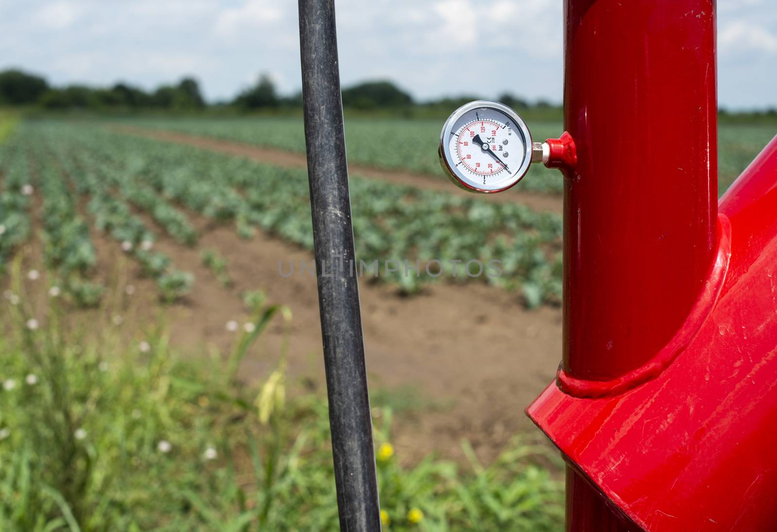 Water pump and pipes on farmland.  by deyan_georgiev