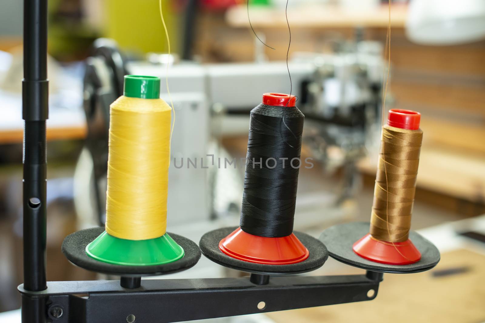 Threads and sewing machine in tailor shop. Close up