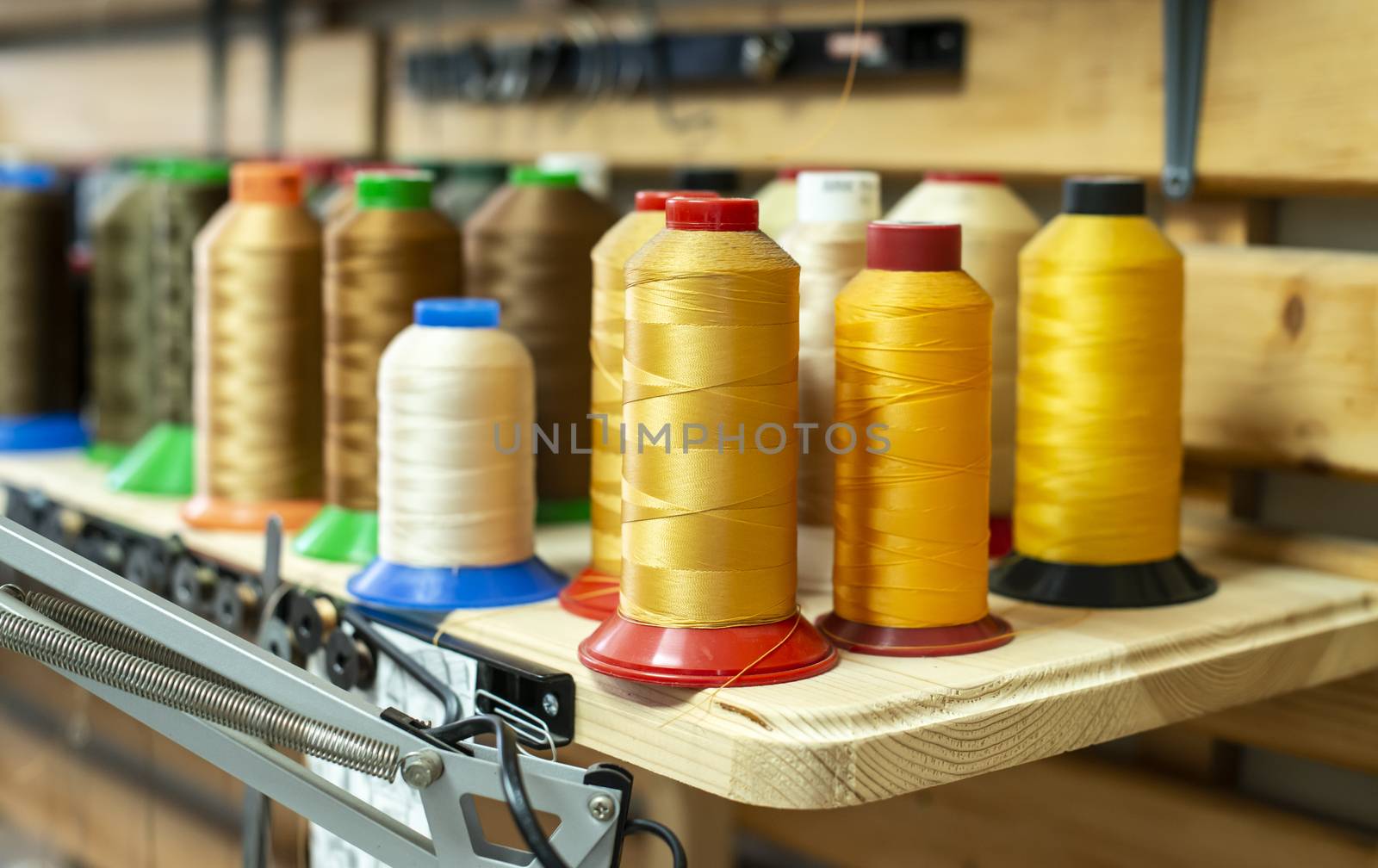 Threads and sewing machine in tailor shop. by deyan_georgiev