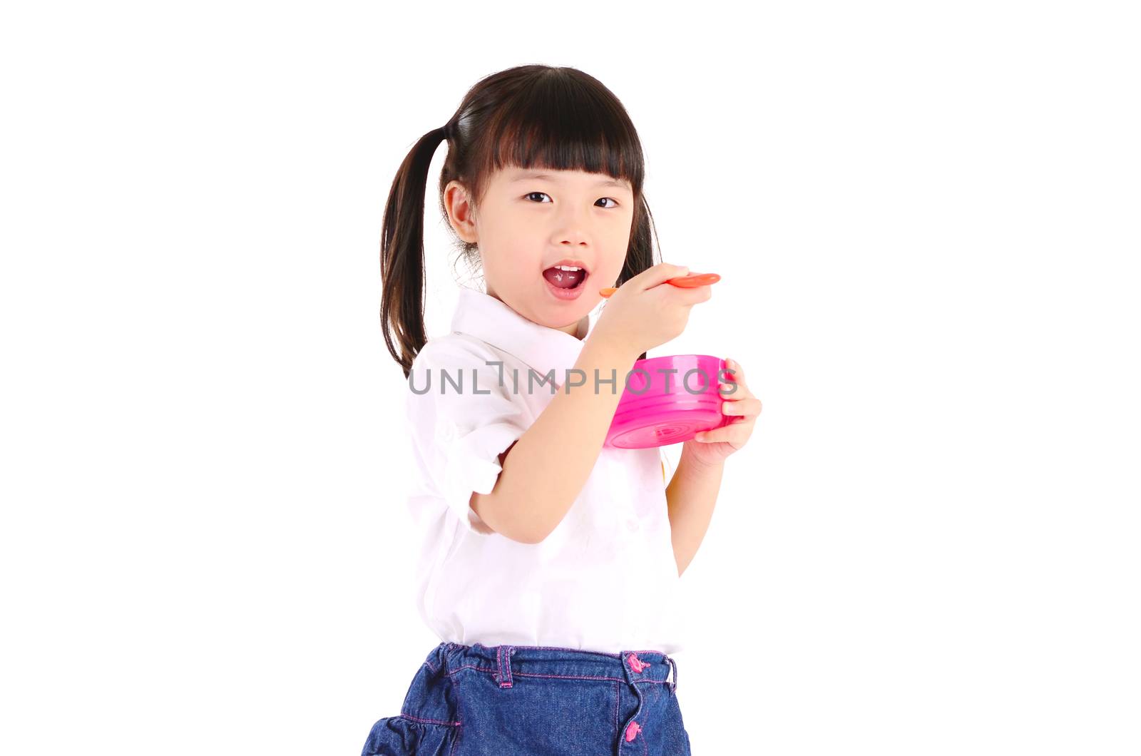 Asian primary school girl eating with her lunch box. Healthy eating concept for schoolchild.