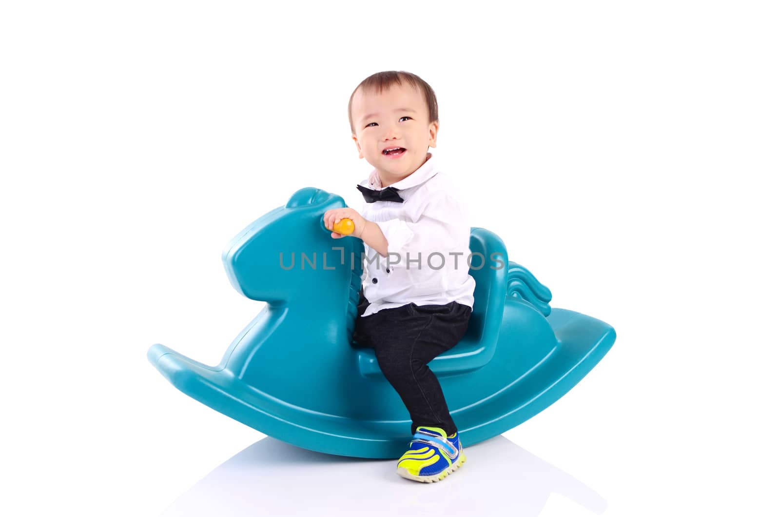 smiling asian boy playing with Toy horse