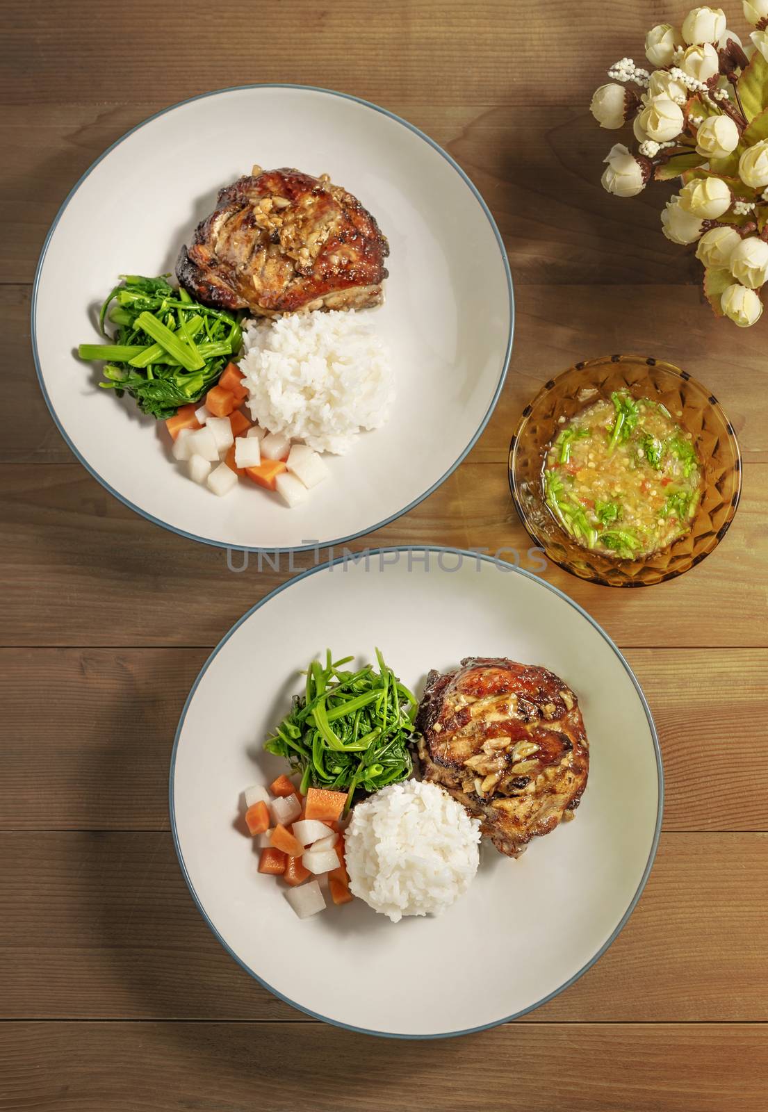 Top view  of grilled chicken served with steamed rice and vegetables