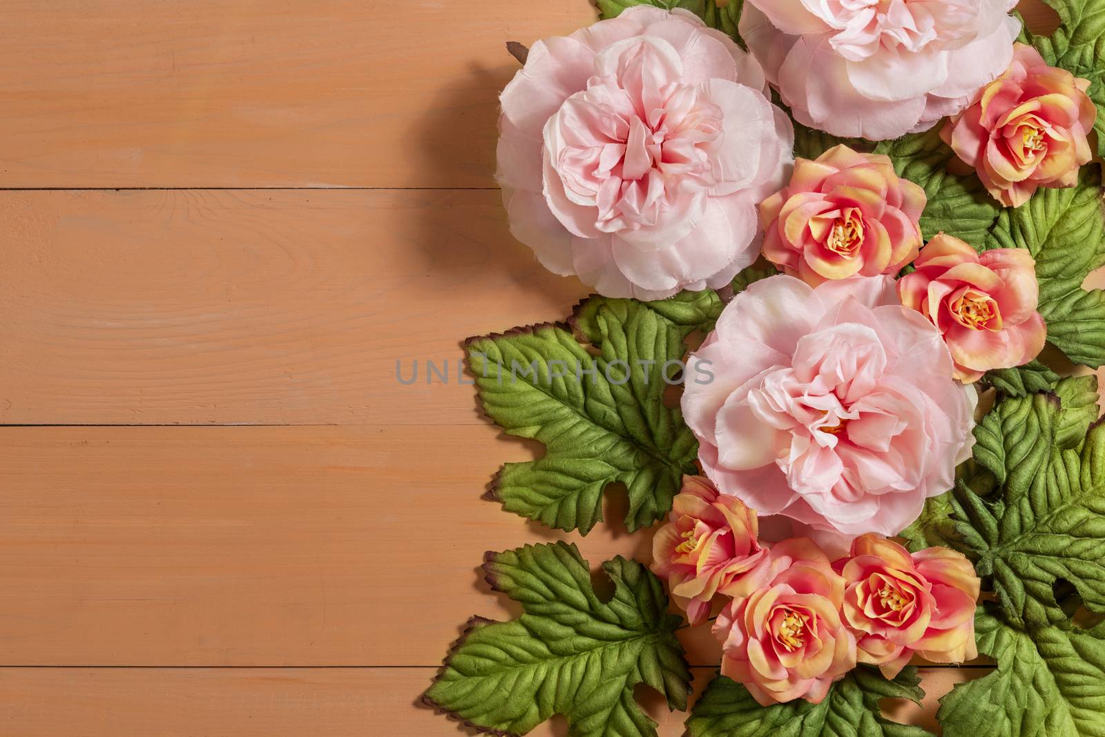 top view beautiful flowers with leaves on wooden background