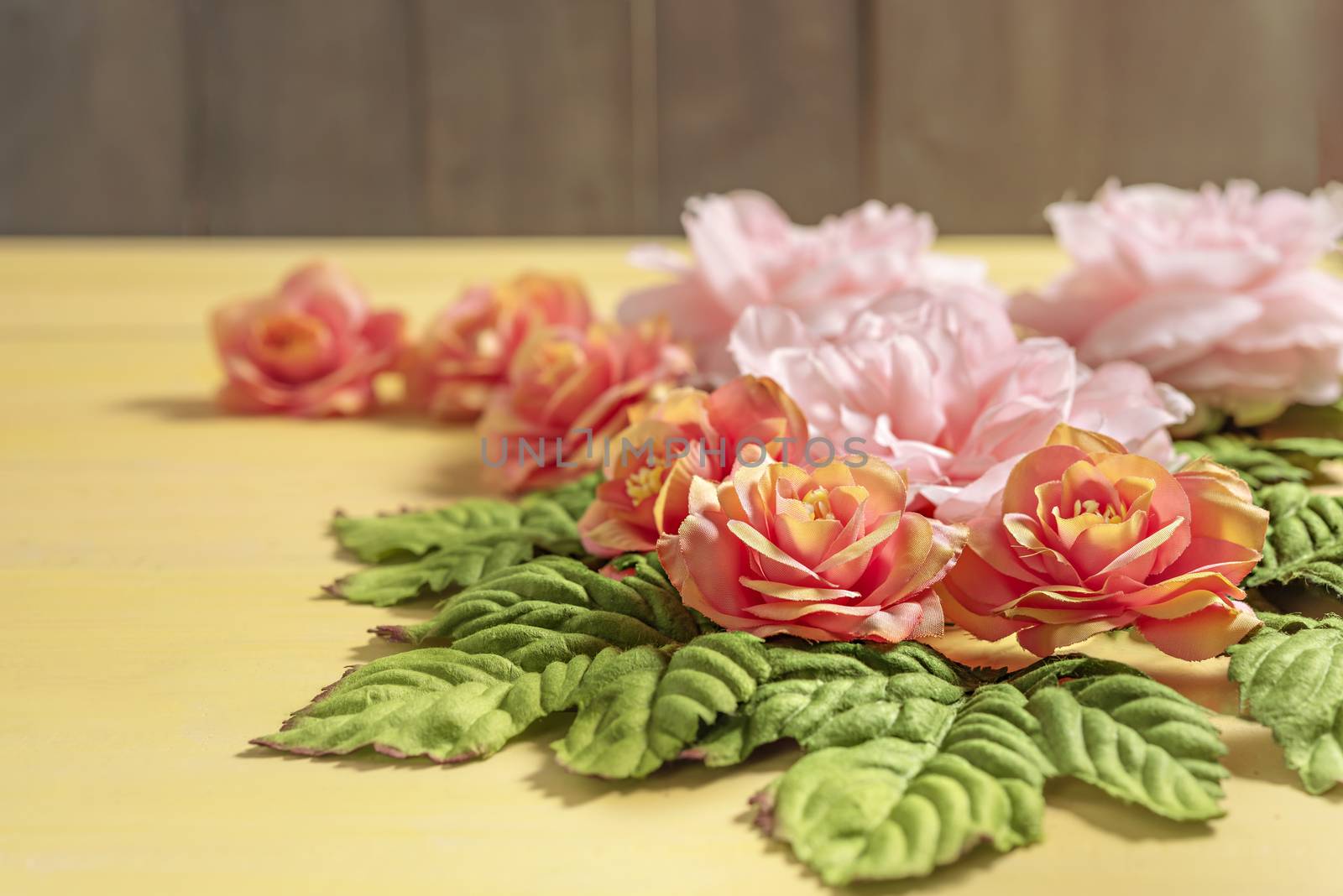 beautiful flowers with leaves on wooden background