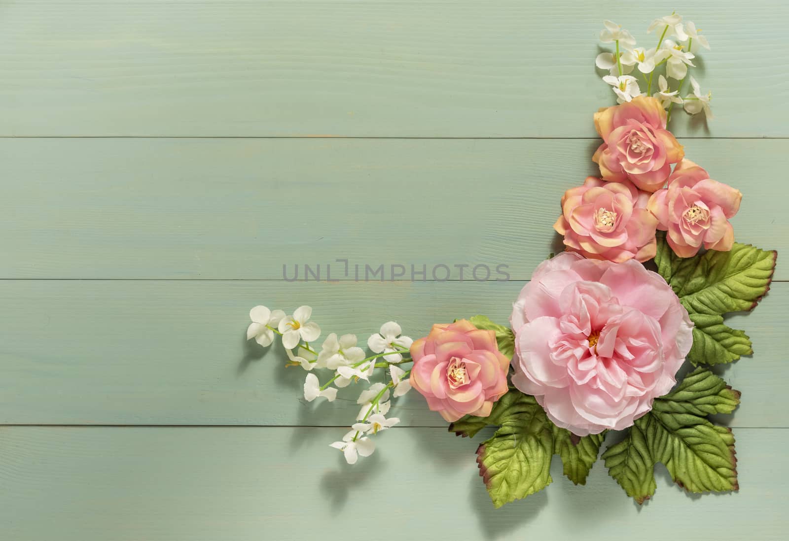 top view beautiful flowers with leaves on wooden background