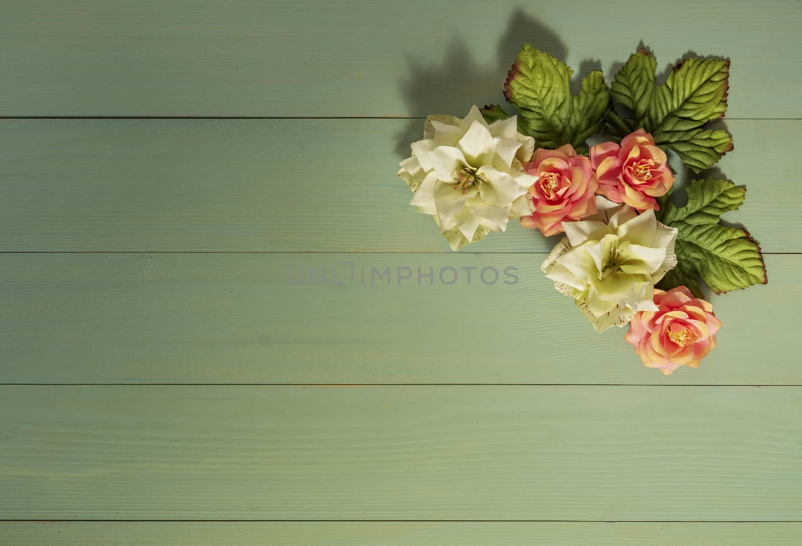 top view beautiful flowers with leaves on wooden background