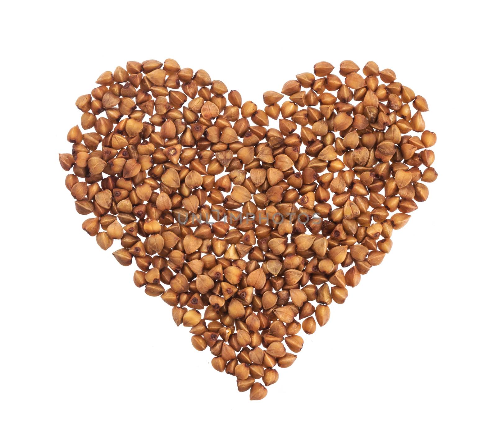 Pile of buckwheat in the shape of heart isolated on white background with clipping path