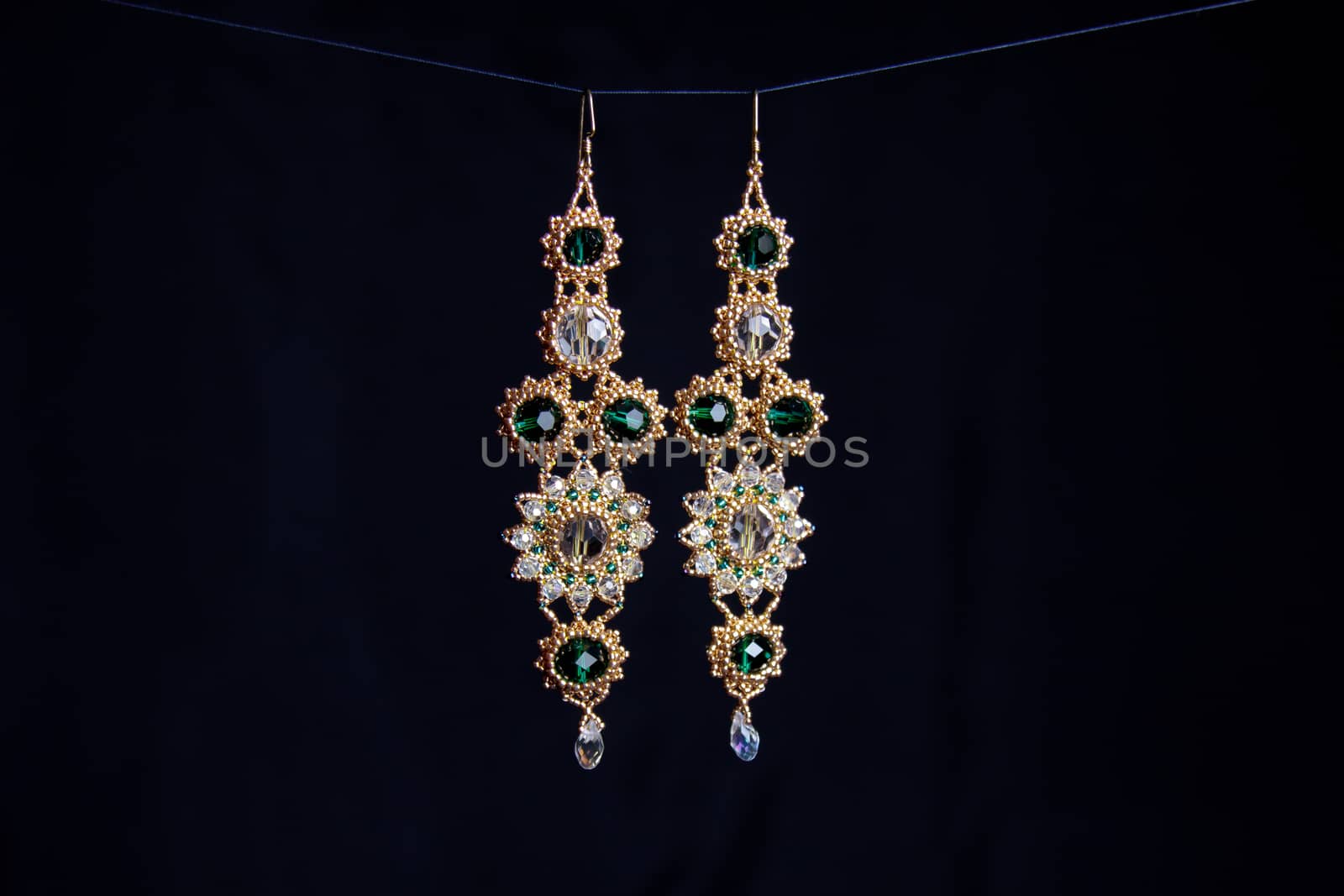 handmade jewelry made of beads in macro. earrings from white beads. earrings from stones by yulaphotographer