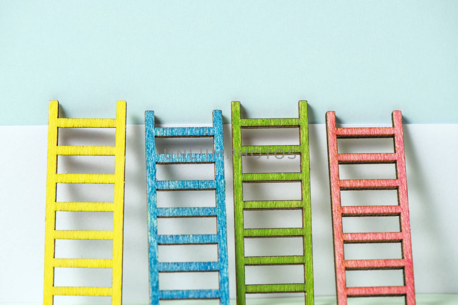 Multicoloured ladders on wall. Pastel tones. Concept for success and growth. Business metaphors.