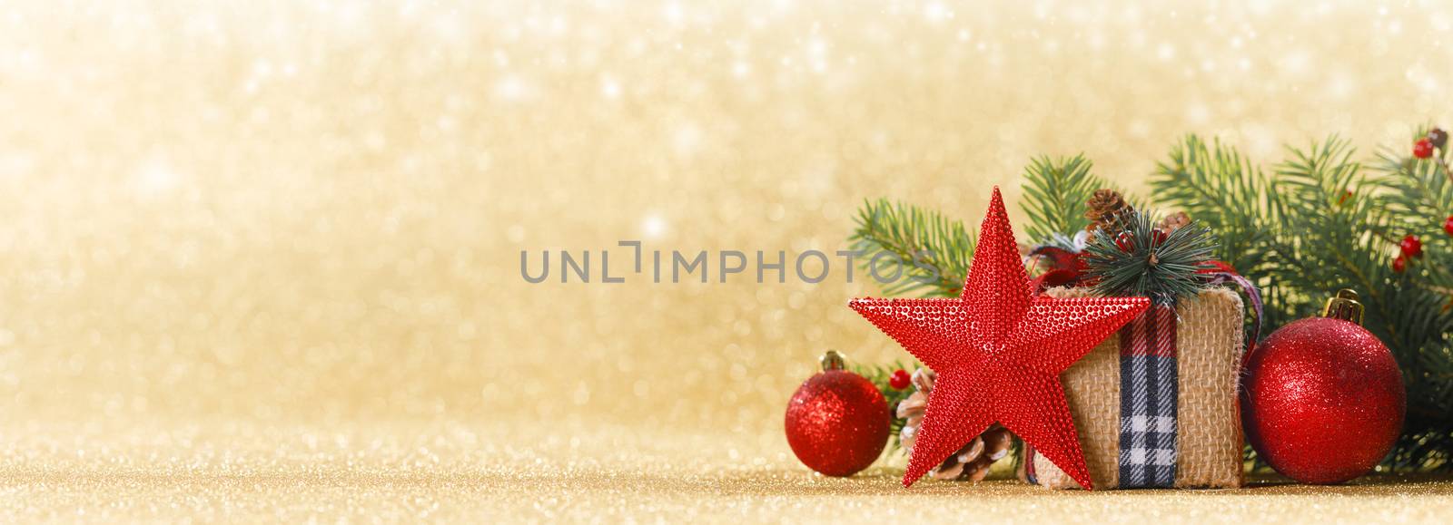 Christmas or new year decorations, craft paper gift box, pine tree branches and cones and balls with bokeh lights background, copy space