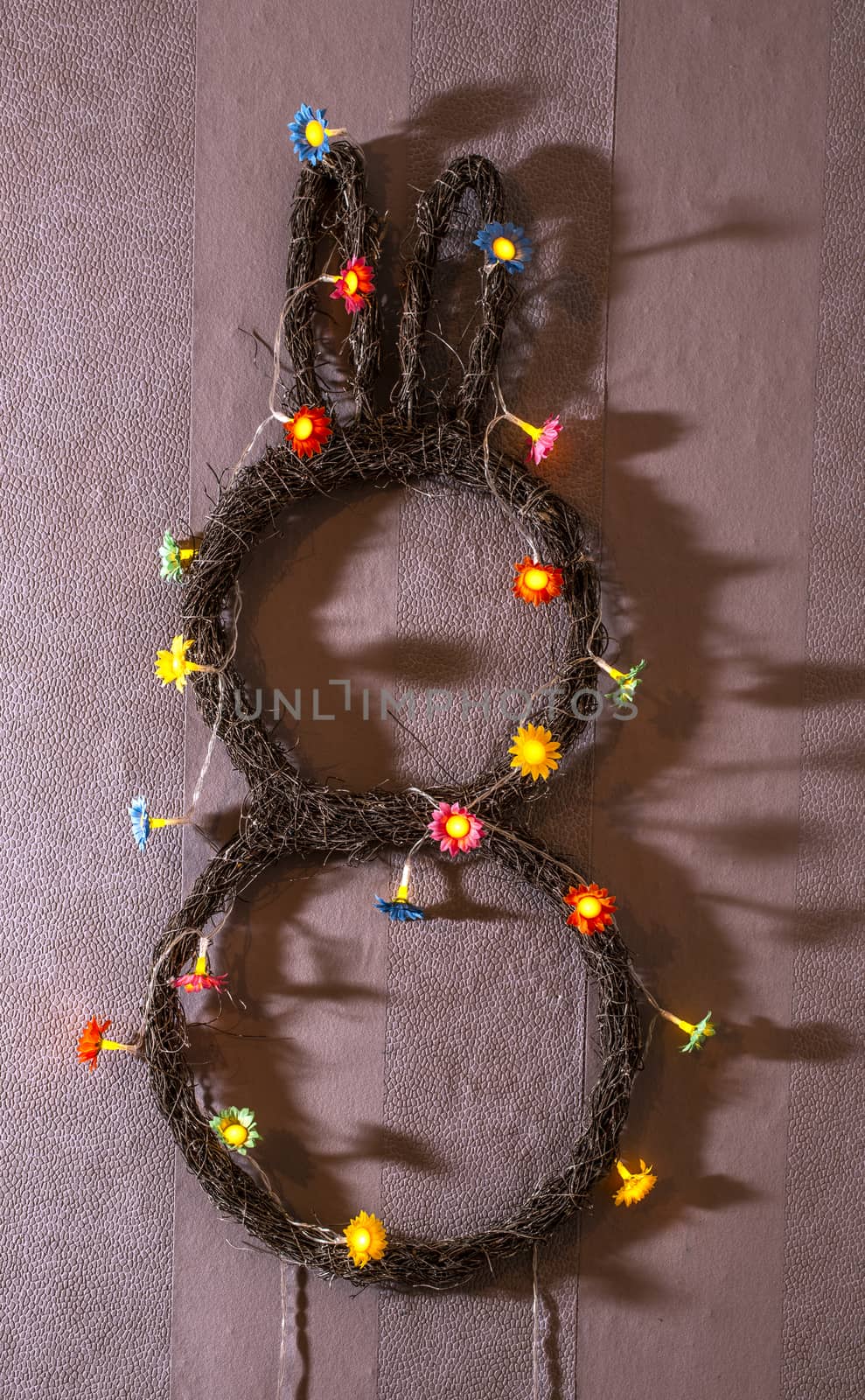 Bunny easter decoration on wall. Flowers lights on bunny shape. 