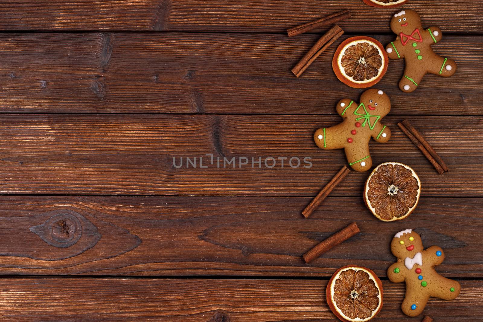Christmas flat lay background with traditional gingerbread cookies dried orange cinnamon on wood