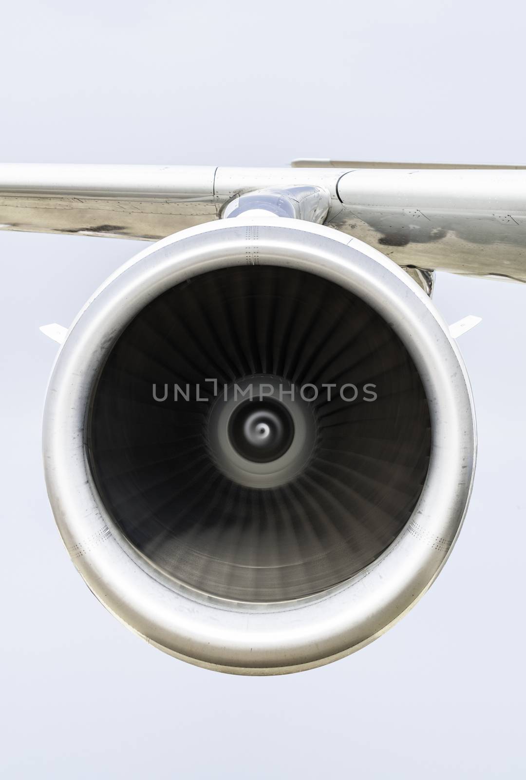 Jet engine on the airplane wing. Close-up frontal view of the jet engine and sky on the background. Air transport conception.