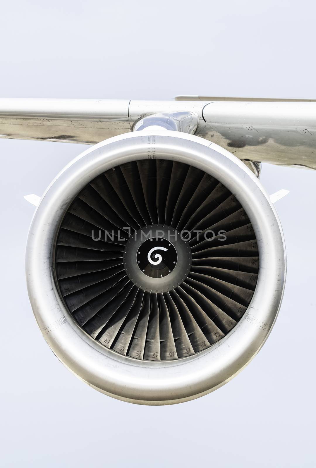 Jet engine on the airplane wing. Close-up frontal view of the jet engine and sky on the background. Air transport conception.