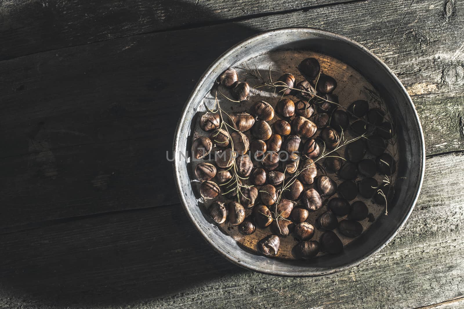 Roasted chestnuts. Vintage baking tray. Natural sun rays from wi by deyan_georgiev