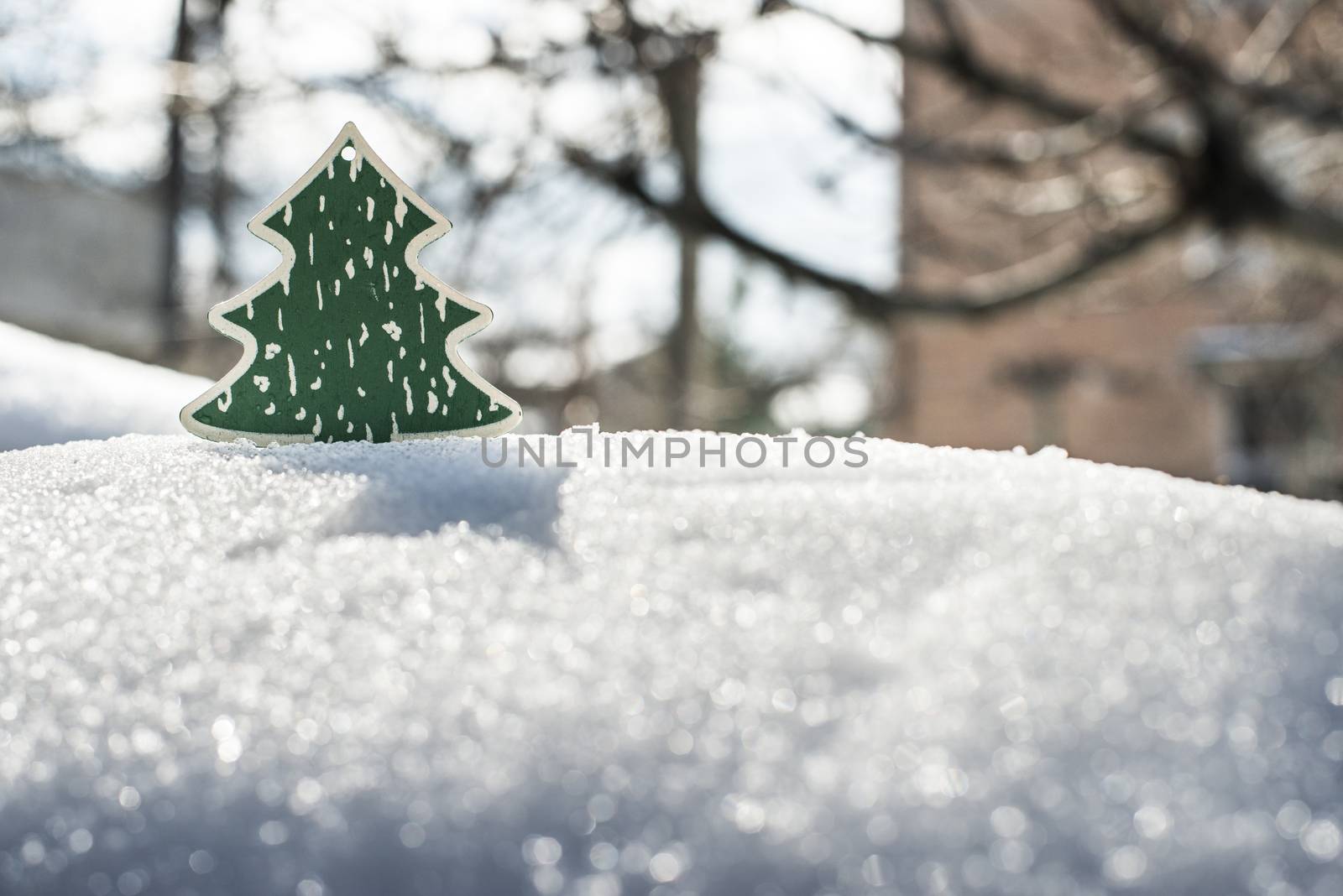 Wooden green christmas tree on snow. Sun light