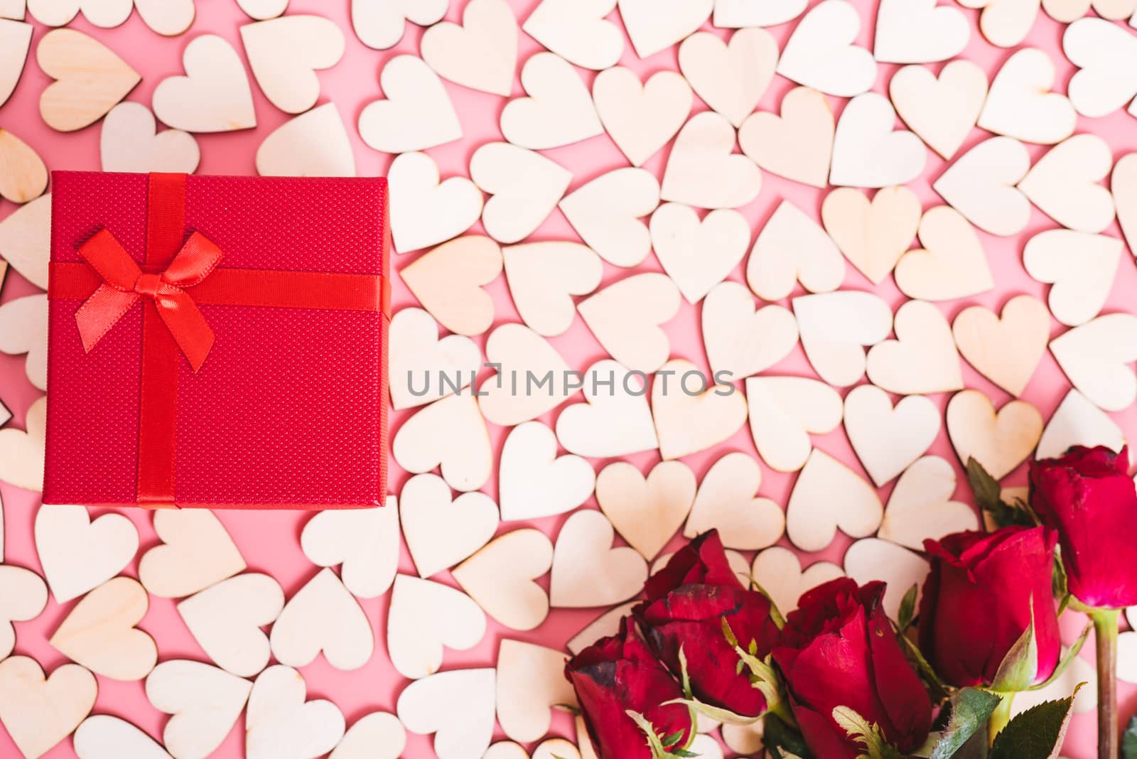 Wood hearts on pink background have a gift box, valentine day concept