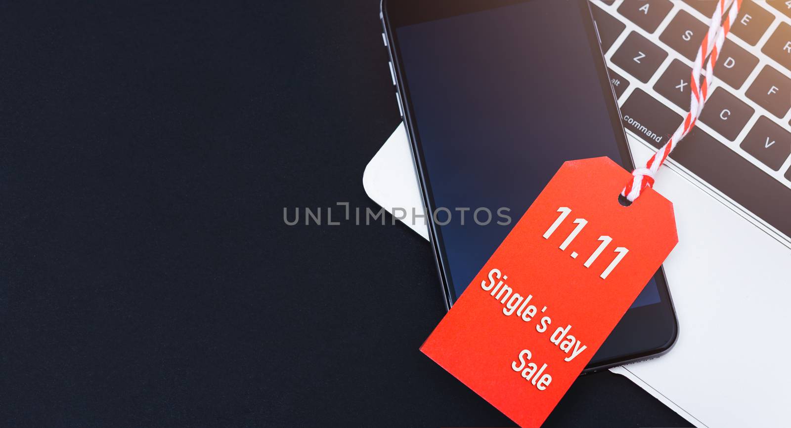 Single's day sale text red tag have mobile smart phone over laptop computer with red background
