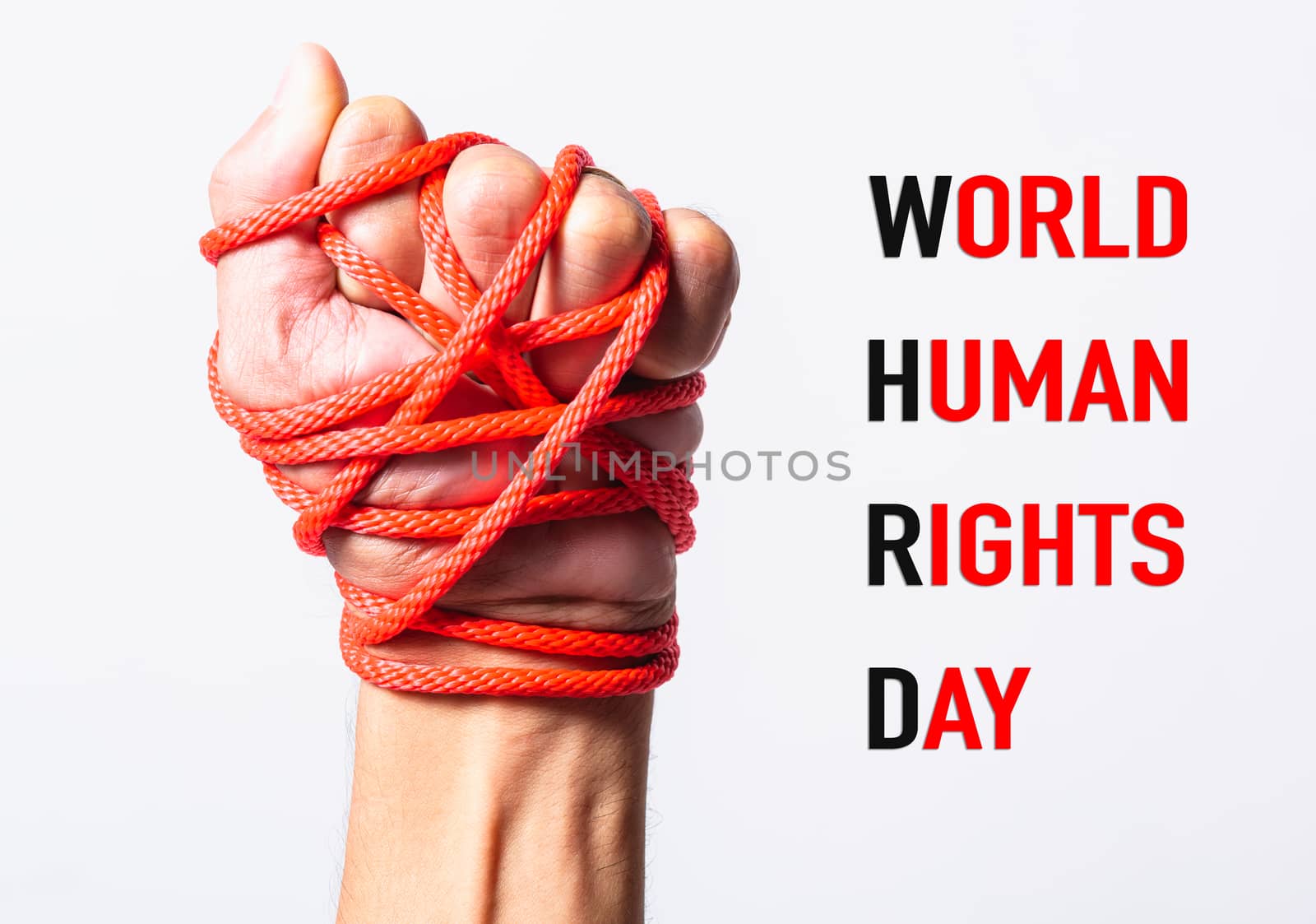 Red rope on fist hand with WORLD HUMAN RIGHTS DAY text on white background, Human rights day concept