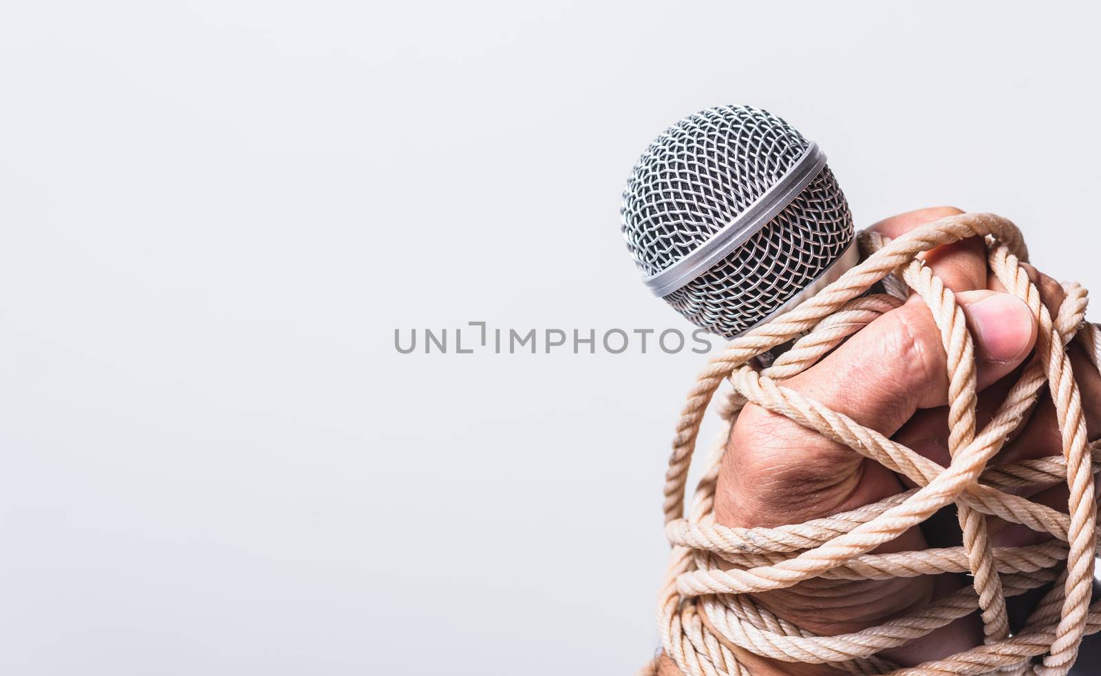 Hand holding microphone and have roped on fist hand by Sorapop