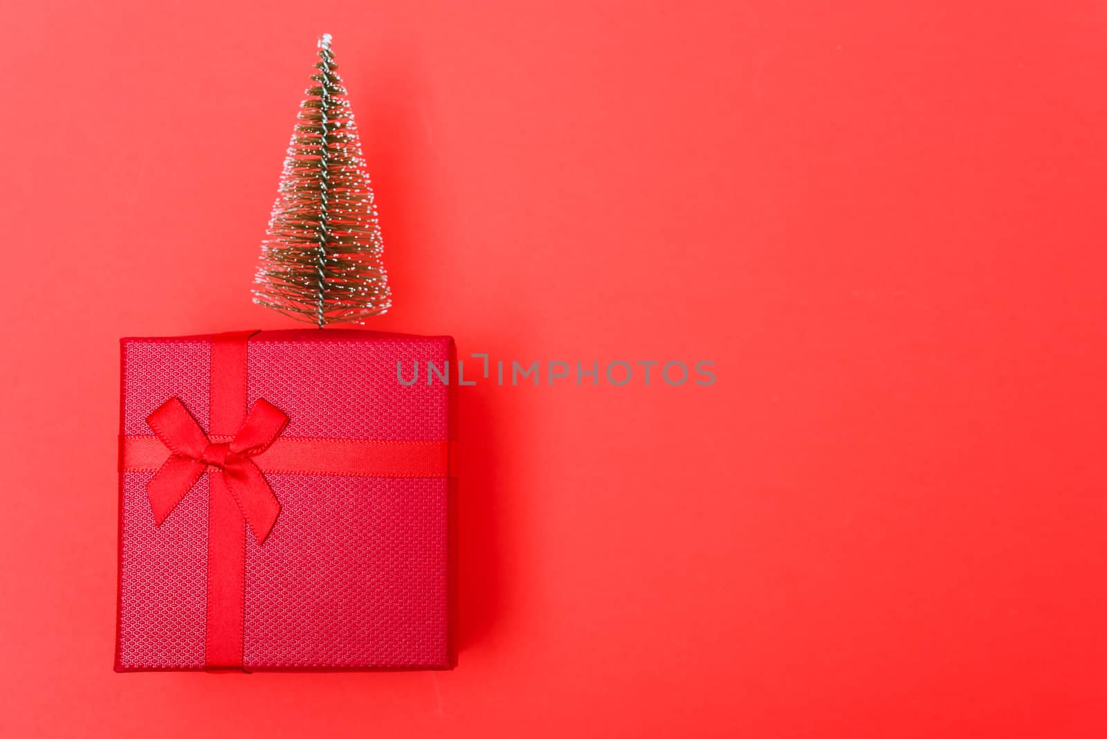 New Year, Christmas Xmas holiday composition, Top view red gift box with green fir tree branch over box on red background