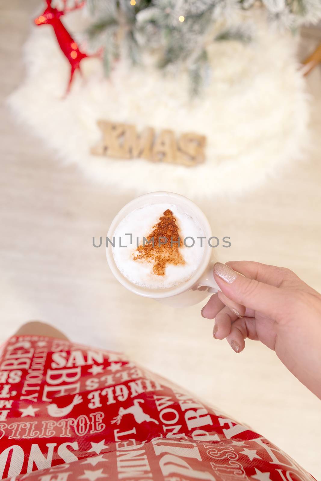 Festive woman holding cappuccino with Christmas design by lovleah