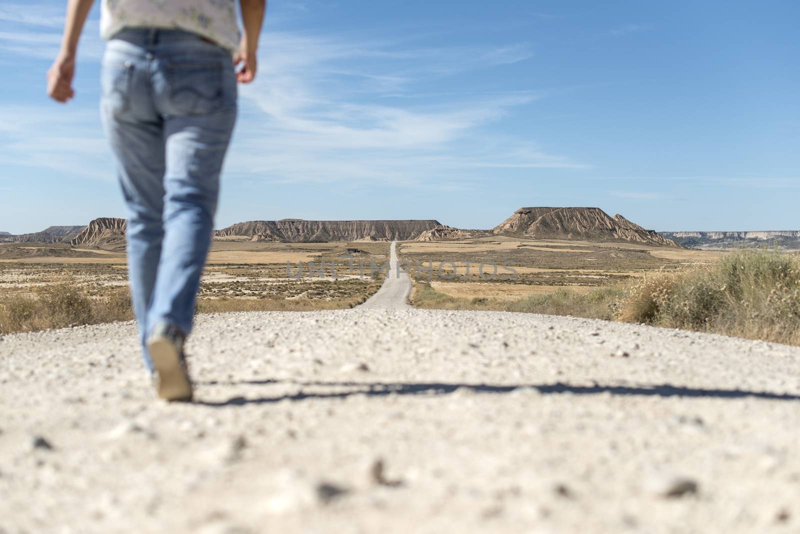 Woman walking on dirt road. Looking like a movie